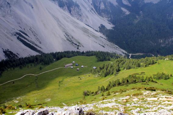 spust z vrha Kozjaka v soncu in vetru, spodaj planina poleg Celovške koče